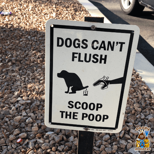 A yard sign with the words " Dog's can't Flush, Scoop the Poop" on it.