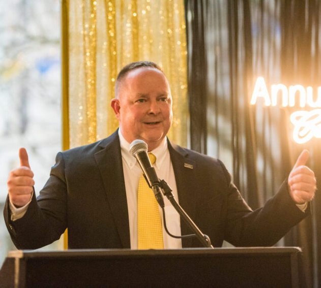 Dan Powell speaking at an awards ceremony.