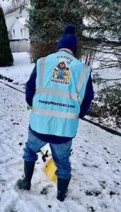 A Poopy Monster Technician Scooping Poop in a yard.