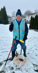A Poopy Monster Technician Scooping Poop in a yard.
